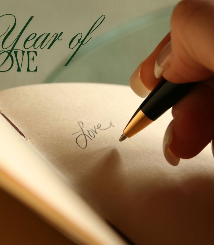 Hand writing the word 'Love' in a journal, title graphic reads My Year of Love